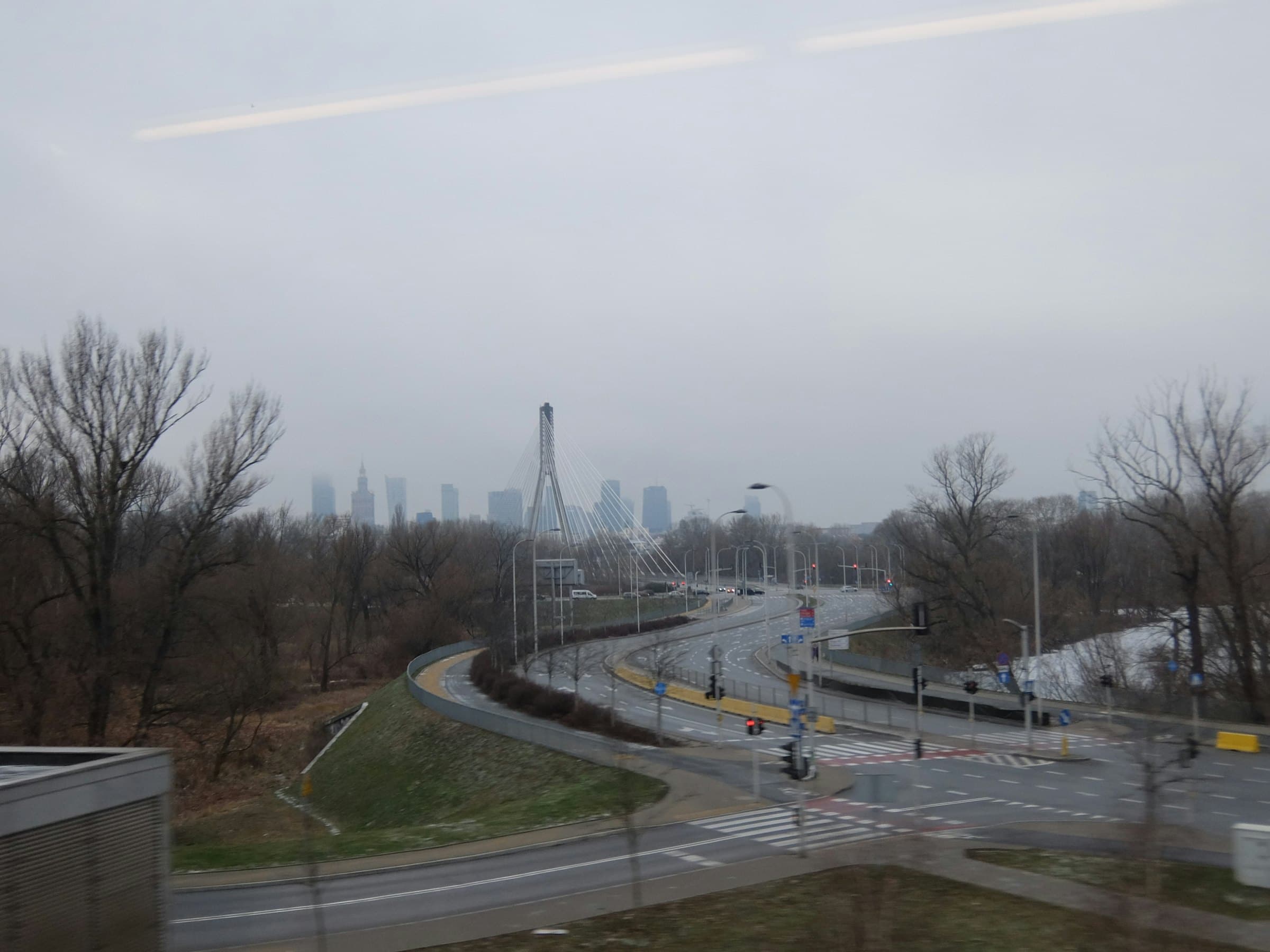 The Warsaw skyline and a cable-stayed bridge in winter fog